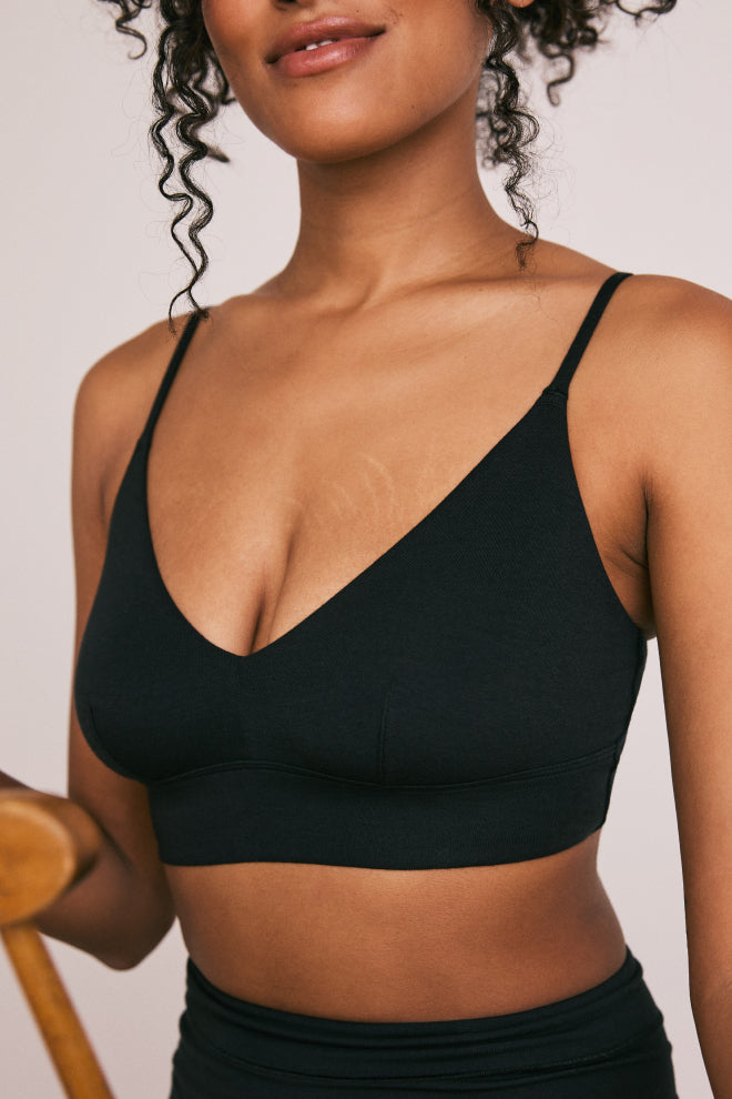 Close-up view of a model wearing the Cloud Cotton Triangle Bralette and Highwaist Boyshort in Black. The image focuses on the upper body, highlighting the comfortable and sleek fit of the bralette, with a glimpse of the highwaist boyshort visible below.